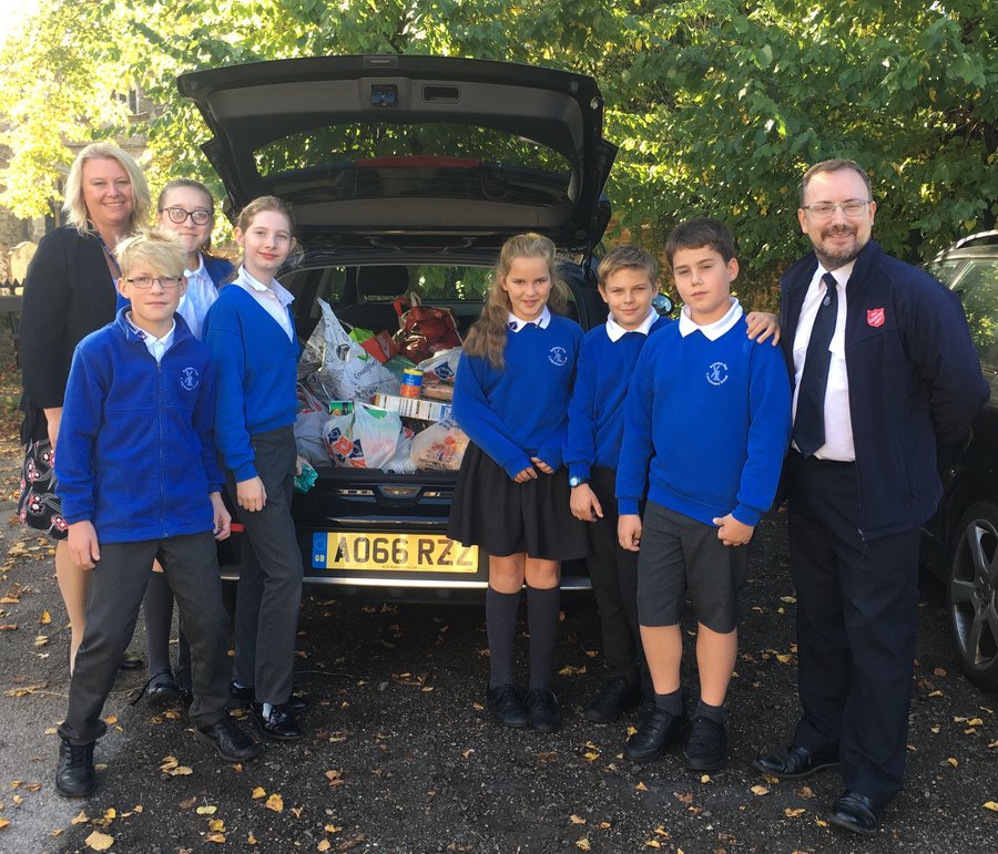 Pupils at our Harvest Festival service help gather donations for the Salvation Army