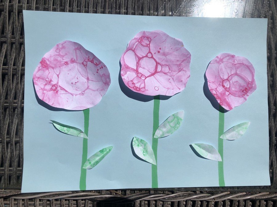 The pink and green paintings were cut up and placed on a blue background to create flowers