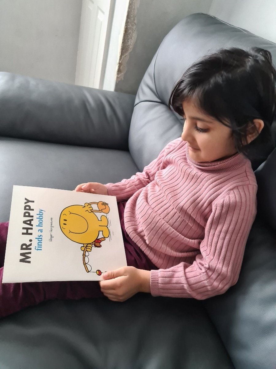 Fatima is enjoying reading her book about Mr Happy.  What hobbies do you like to do?