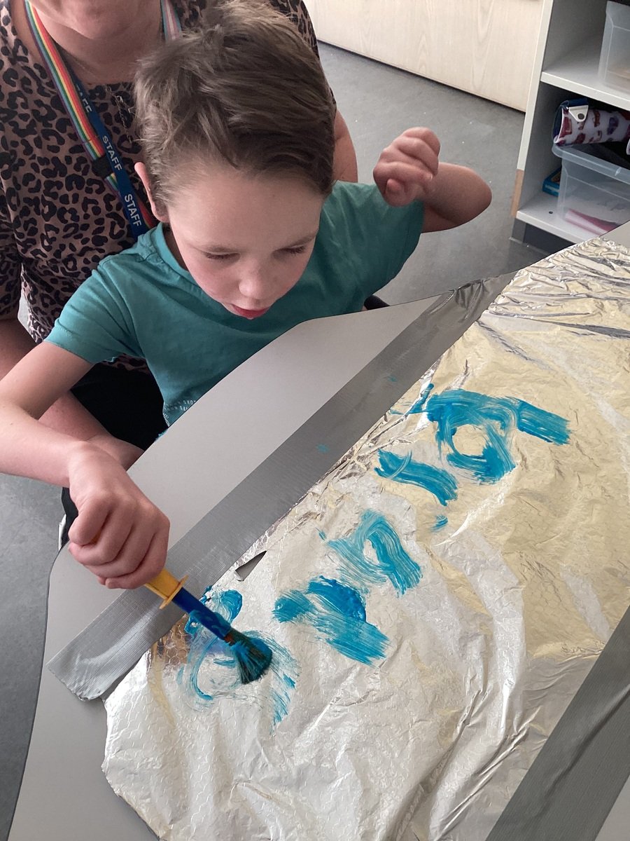 B, Year 5, pathway 2, writing his name using paint on tin foil.Wow!