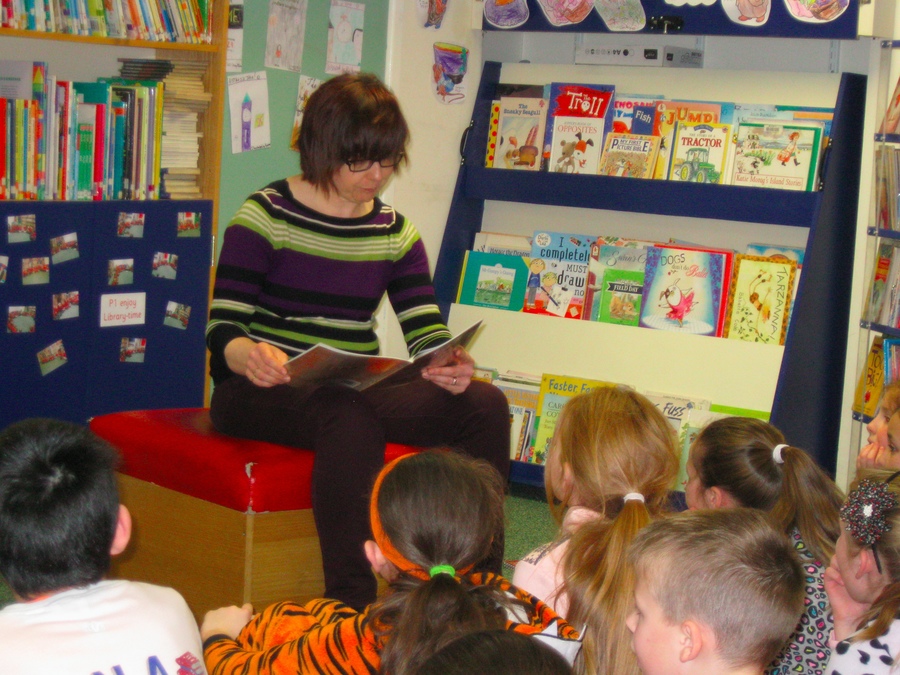 P.5 enjoy listening to some stories in the library.
