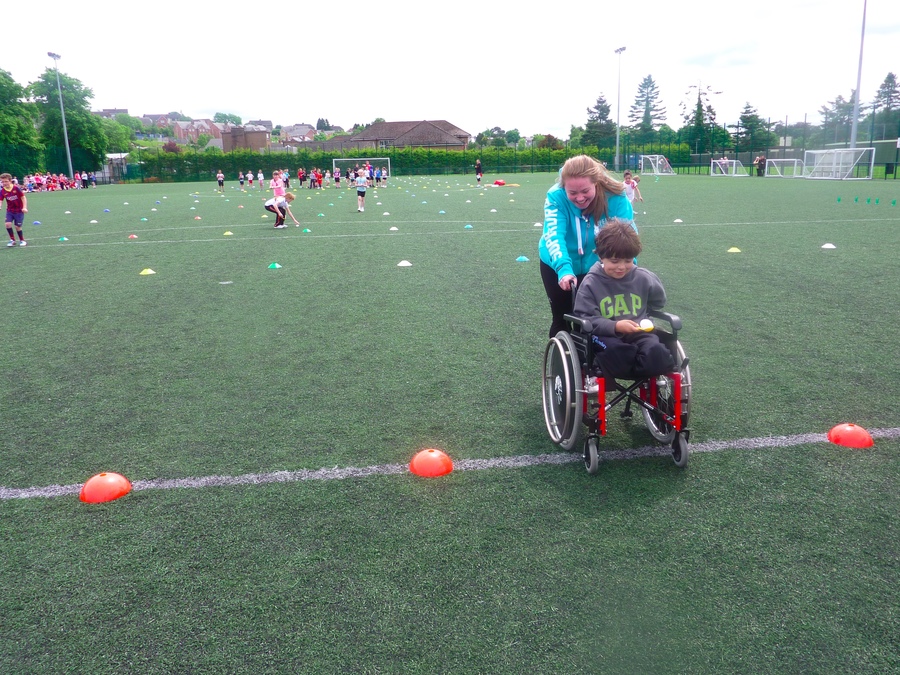 Megan pushes Oliver over the finish line in the ball and spoon race.