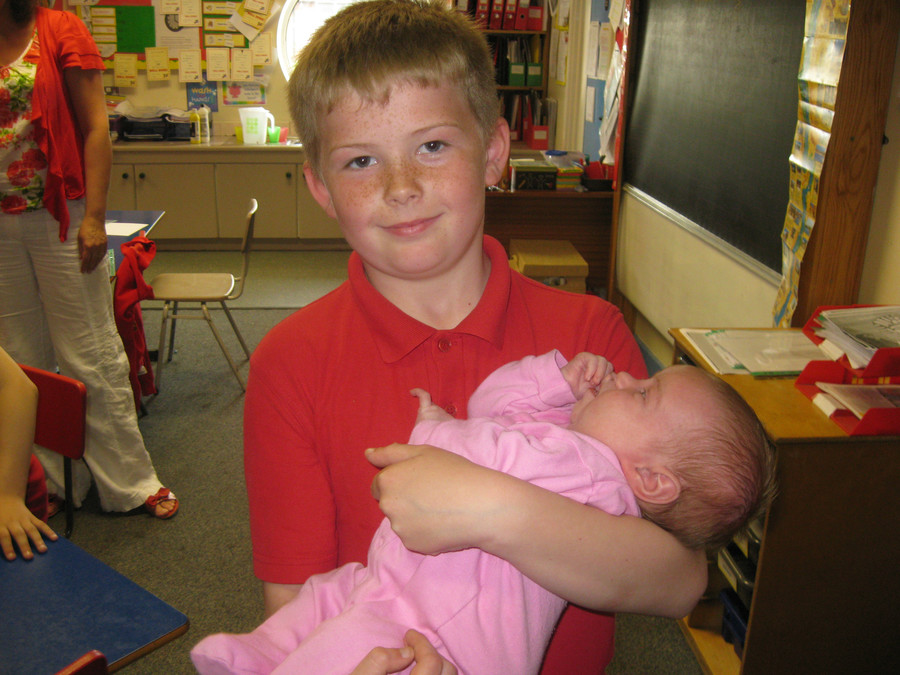 Lewis proudly holds his baby sister Liela