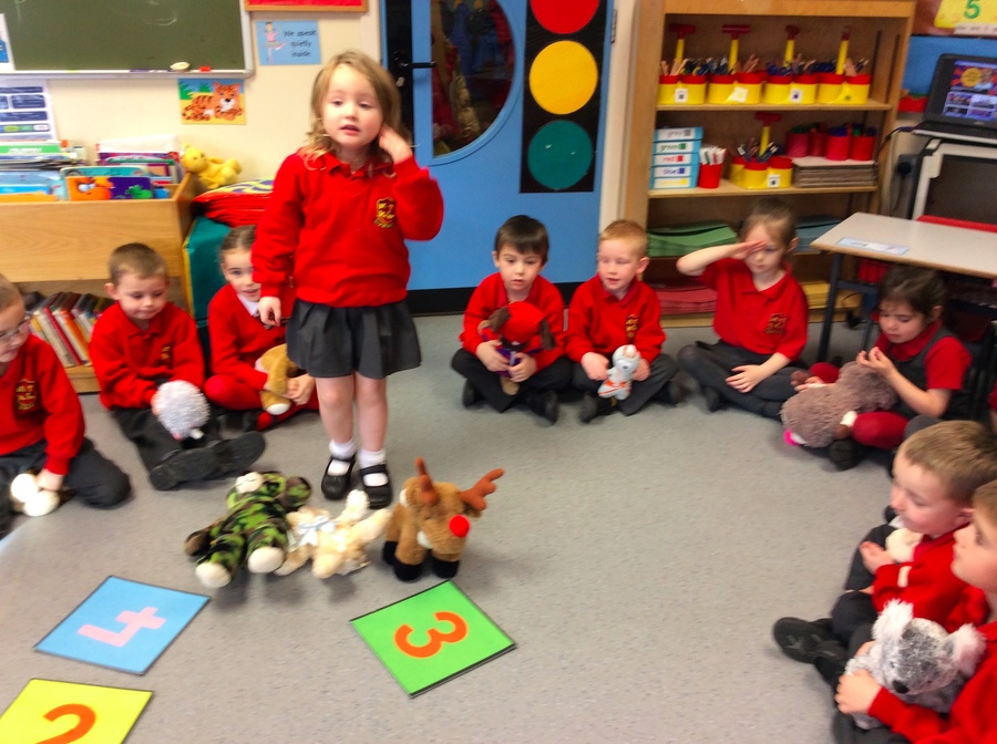 Sienna counting a set of three teddies