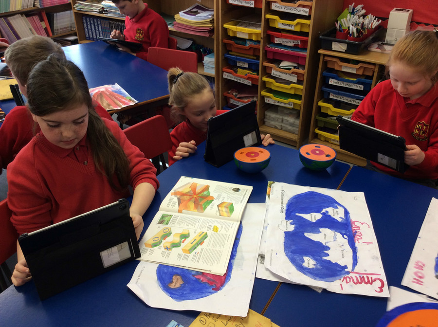Lorin, Emma and Holly are selecting natural disaster images to use. 