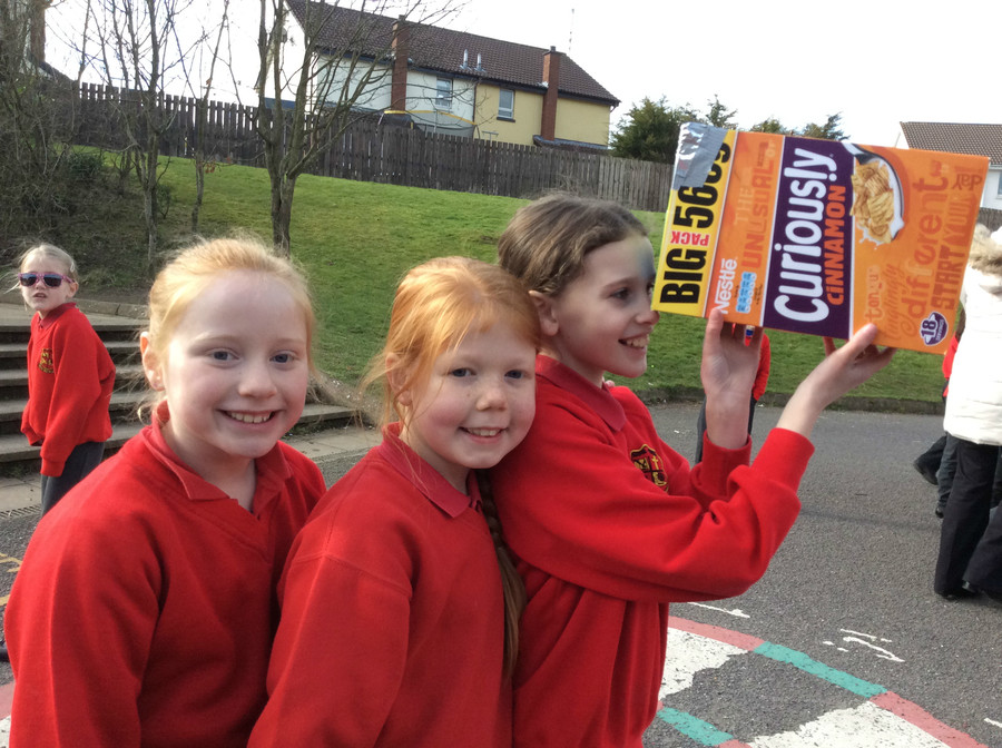P.5 girls try to view the eclipse through a viewer made from a cereal box.