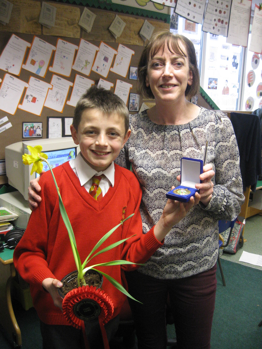 Matthew displays his medal to his mum.