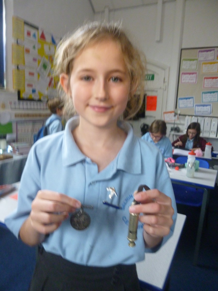 Harriet showing her Grandfather's trench whistle and medal.